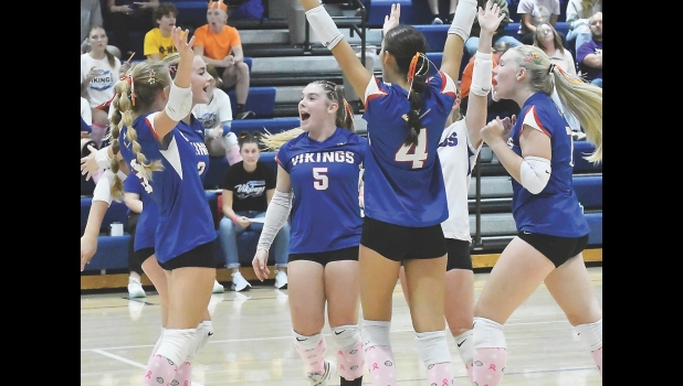 The Vikings celebrate consecutive ace serves during set two on Thursday night against Lake Mills.