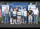 Iowa Secretary of Agriculture Mike Naig (left) and Iowa Farm Bureau Federation President Brent Johnson (right) presented the Rugland family with the Iowa Heritage Farm award at a ceremony on August 20 during the Iowa State Fair.
